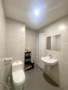 a bathroom with a white toilet and a sink at Pantai Puteri Melaka - Seaview 2 Bedroom in Kampong Pantai Dusun