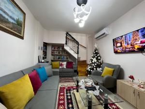 a living room with a couch and a christmas tree at Duplex Mino, Pazari i Vjetër Korçë in Korçë