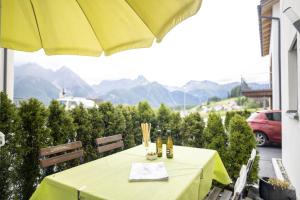 - une table jaune avec des bouteilles de vin sur le balcon dans l'établissement Chasa Bazzell, à Ftan