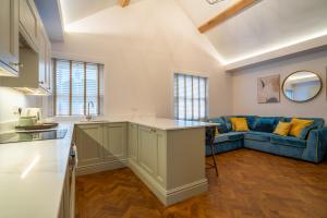 eine Küche und ein Wohnzimmer mit einem blauen Sofa in der Unterkunft Hazelwick Apartment in Crawley