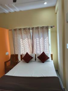 um quarto com uma cama grande e uma janela em Royal Comforts em Mysore