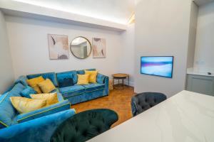 a living room with a blue couch and a mirror at Hazelwick Apartment in Crawley