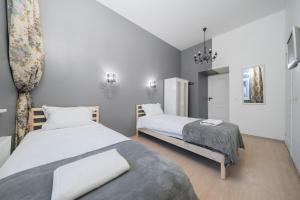 Un dormitorio con 2 camas y una silla. en Halės Guest House - Lollo Luxury en Vilna