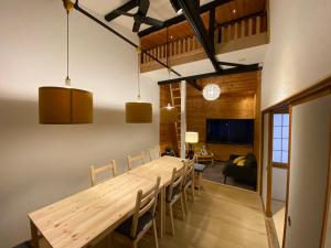 a dining room with a long wooden table and chairs at FTH Moon Light 3min to Sta. in Shimo-yoshida
