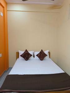 a bedroom with a white bed with three pillows at Royal Comforts in Mysore