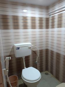 a bathroom with a white toilet in a room at Royal Comforts in Mysore