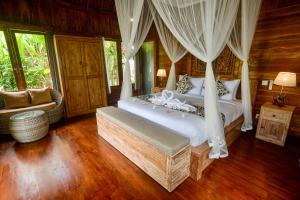 a bedroom with a bed with a canopy at The Banana’s Kumbe Villa in Tampaksiring +80 photos