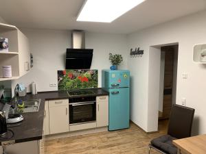 uma cozinha com um frigorífico azul num quarto em Ferienappartement Albschätzle 