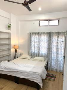 1 dormitorio con cama y ventana en The White House Villa, en Udaipur