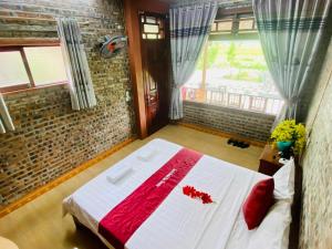 a bedroom with a large bed with red pillows at Tam Coc Mountain View Homestay in Ninh Binh