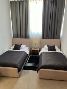 a bedroom with two beds and a window at ZOO hotel in Osijek