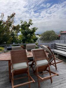 Willowbank Motel في كايكورا: كرسيين وطاولة خشبية على سطح السفينة