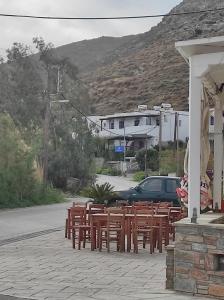 a row of wooden tables and chairs on a street at Kea Island in Korissia
