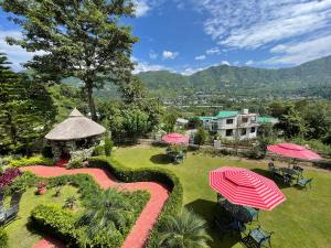 eine Luftansicht auf einen Garten mit einem Sonnenschirm in der Unterkunft Sangita Resorts in Nainital