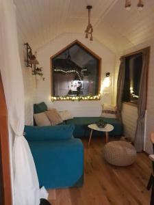 a living room with a blue couch and a mirror at Natura Tiny House in Mărişel