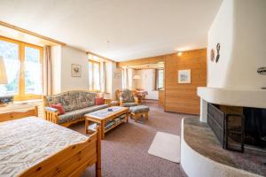 a living room with a bed and a fireplace at Chasa Plazza Gronda in Lavin