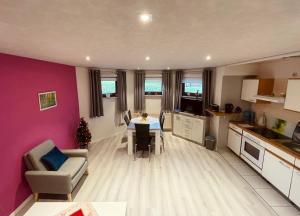 a kitchen and living room with a table and chairs at FEWO Brockenblick in Allrode