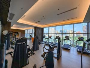 un gimnasio con muchas cintas de correr y máquinas elípticas en YOHO Treasure Island Hotel en Macao