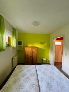 sypialnia z łóżkiem i zieloną ścianą w obiekcie FEWO Brockenblick w mieście Allrode