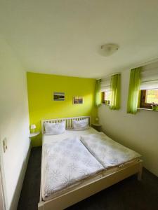 a bedroom with a large bed with yellow walls at FEWO Brockenblick in Allrode