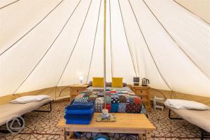 een kamer met een bed in een tent bij Willow Valley Glamping in Bude