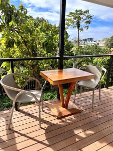 una mesa de madera y 2 sillas en una terraza en Ononui Lodge Airport, Ocean-View, Private Bathroom and Balcony, Free WiFi and Parking, On-Site Car Rental en Faaa