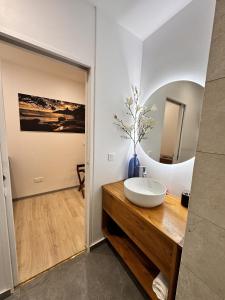La salle de bains est pourvue d'un lavabo blanc et d'un miroir. dans l'établissement Ononui Lodge Airport, Ocean-View, Private Bathroom and Balcony, Free WiFi and Parking, On-Site Car Rental, à Fa'a'ā