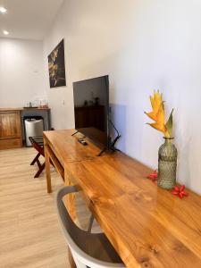 une table en bois avec un vase au-dessus dans l'établissement Ononui Lodge Airport, Ocean-View, Private Bathroom and Balcony, Free WiFi and Parking, On-Site Car Rental, à Fa'a'ā
