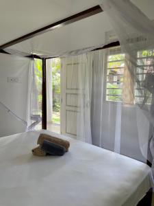 a white bed with a towel on it with a window at Casa Tharin Madiha in Matara