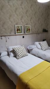 2 Betten nebeneinander in einem Zimmer in der Unterkunft EL DESCANSO CELTA in El Raso