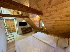 a bedroom with a white bed in a wooden ceiling at Boutique Cottage Tkalcovna in Rokytnice nad Jizerou
