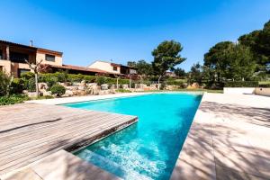 a swimming pool with a wooden deck next to a house at Fabuloso Birdie 8 : entre mar y montañas in Bonmont Terres Noves
