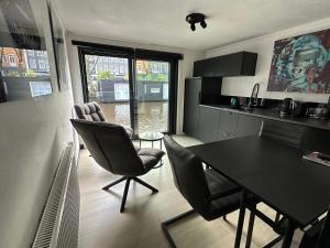 una cucina e una sala da pranzo con tavolo e sedie di Amsterdam-Houseboat-Amstel ad Amsterdam