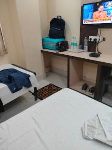 a room with a bed and a desk with a tv at Triumph inn Bhubaneswar in Bhubaneshwar