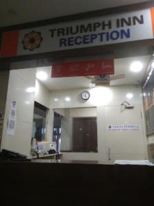 a turnipkin inn reception with a clock on the wall at Triumph inn Bhubaneswar in Bhubaneshwar