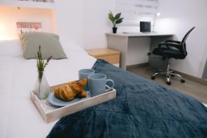- un plateau avec des croissants et des tasses sur le lit dans l'établissement Piso compartido Delyrent, SFJ, à Jaén