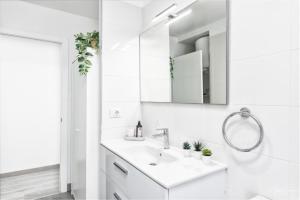 Un baño blanco con lavabo y espejo. en Cerca Nueva, en Las Manchas 35 fotos más