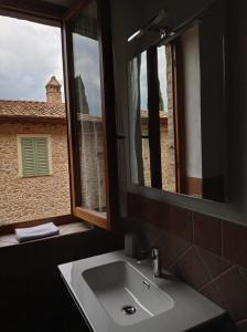 łazienka z umywalką, lustrem i oknem w obiekcie Agriturismo Le Case di San Vivaldo w mieście Montaione
