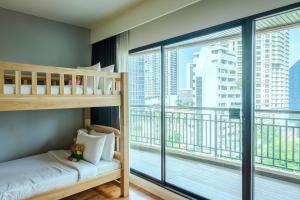 曼谷Somerset Park Suanplu Bangkok的一间带双层床和大窗户的卧室
