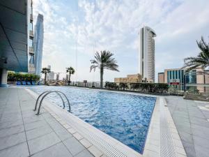 a swimming pool in a city with tall buildings at Frank Porter - Ocean Heights in Dubai