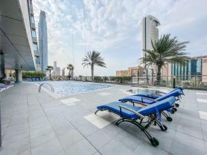 a group of blue chairs sitting next to a swimming pool at Frank Porter - Ocean Heights in Dubai