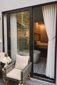 um quarto com uma banheira, uma cadeira e uma janela em Cao Son Hotel em Bắc Quang