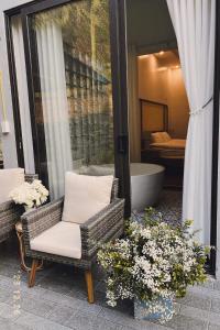 um pátio com 2 cadeiras, uma banheira e flores em Cao Son Hotel em Bắc Quang