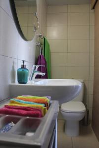 a bathroom with a sink and a toilet and a mirror at Eden Beach Apartment 611 in Limassol
