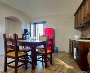 Casale di lusso panoramico في Lettere: مطبخ مع طاولة وكراسي وثلاجة حمراء
