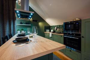 eine Küche mit grünen Schränken und einer hölzernen Arbeitsplatte in der Unterkunft Cabin Home Apartment in Odorheiu Secuiesc