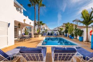 una piscina con sillas y una terraza con una casa en Villa Oasis Galé - Luxury Villa with private pool, AC, free wifi, 5 min from the beach, en Albufeira