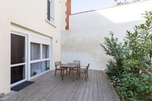 patio con mesa, sillas y TV en Tranquilis - Studio hypercentre terrasse parking en Reims