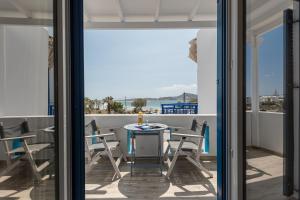 Un patio con una mesa y sillas en un balcón. en Sun Beach Hotel, en Naxos Chora