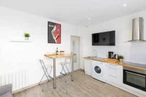 a kitchen with a table and a sink and a washing machine at Tranquilis - Studio hypercentre terrasse parking in Reims